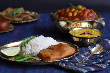 dishes of national Indian cuisine on a dark blue background. traditional Indian home-cooked dinner. rice, dal, sabji, aloo parantha, gulabjamun, masala