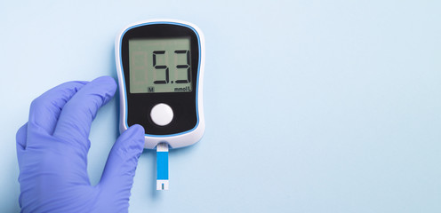Banner doctor`s hand holding glucose meter