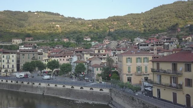 Drone shot of the small ancient village of Dolceacqua in Northern Italy in the morning sun during summer. Flying over the famous ancient bridge.