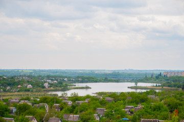 Fototapeta premium Village by the river under a clear blue sky in the summer