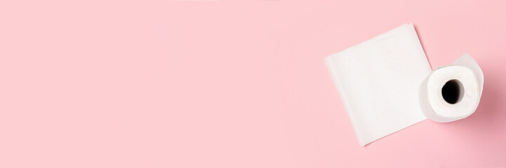 Roll of paper towels on a pink background. Concept is 100% natural product, delicate and soft. Flat lay, top view. Banner