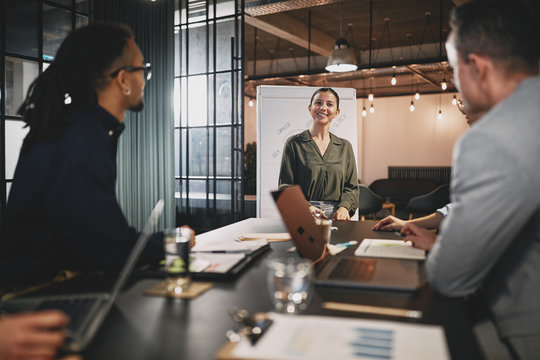 Smiling Businesswoman Giving A Presentation To Office Coworkers