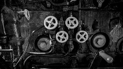 Black and white photo of valves and faucets on old steam powered train engine