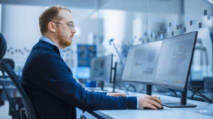 Shot of a Heavy Industry Engineer Working on Personal Computer, Screen Shows CAD Software Showing...