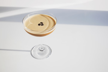 Stylish coffee cocktail on the white table in natural sunlight