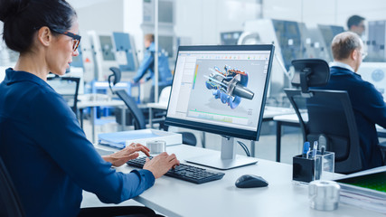 Industrial female Engineer Working on a Personal Computer, Screen Shows CAD Software with 3D...