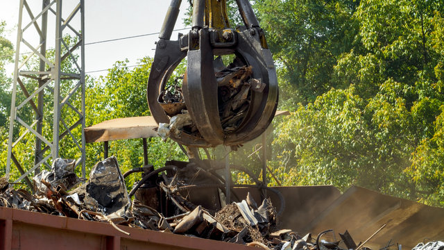 Photo of metal scrapyard with working heavy machines