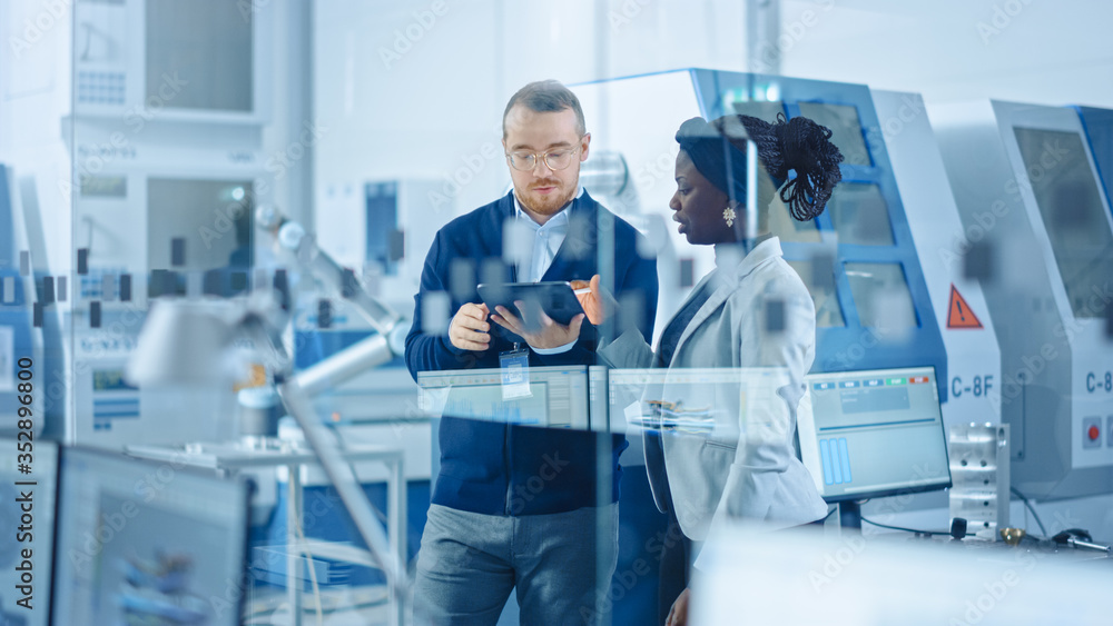 Aufkleber female industrial engineer stands with male project supervisor, they use tablet computer and discuss