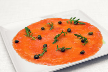 Smoked salmon carpaccio with rocket salad. Restaurant menu. White background.