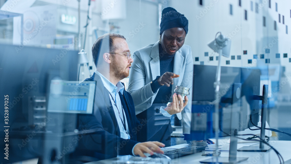 Poster modern factory: female project supervisor talks to a male industrial engineer who works on computer.