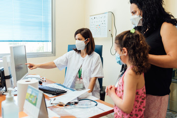 The pediatric doctor talks to the family at the clinic about the medical results.