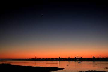 Fototapeta premium moon in the sky over a river after the sun has set