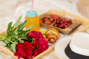 breakfast in bed with coffee, croissants, strawberries and juice