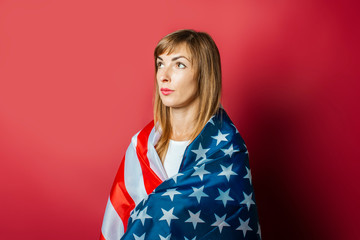 Young girl holds the US flag on a pink background. Concept patriot, holiday, independence day, memorial day, US visa, emigration to USA, education in USA