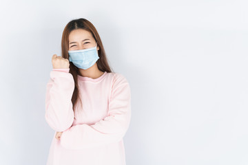 Asian beautiful happy hipster woman wearing a medical protection face mask for protect the coronavirus, filter dust PM 2.5 and cold and raise her hand to fight them on white background