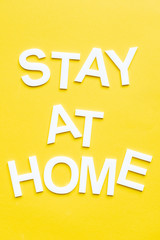 Top view of stay at home white lettering on yellow background