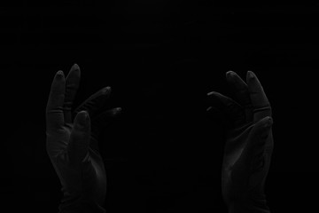 hands in black gloves in the darkness