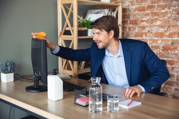 Cleaning the workplace before start. Young man, manager return to work in his office after...