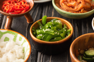 selective focus of green bell peppers and red chili peppers near korean kimchi and rice