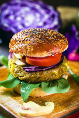 tasty vegan hamburger, hamburger made of vegetables and proteins, with arugula, purple tomato, mushroom and french fries. Healthy food without the addition of animal origin elements.