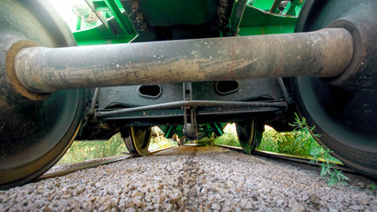 View from the ground on big metal train axxle on railroad
