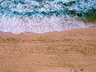 Footprints on the beach, ocean. Top view of the beach. Background, travel, vacation concept.