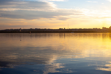 Beautiful sunset in the city. City photographed from a ship. Sunset on the water. Dawn in the city