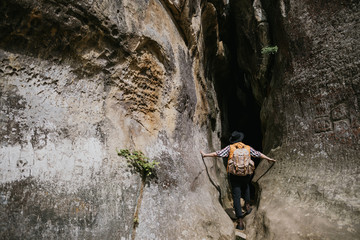 A young male traveler enters a mountain gorge. Extreme rest