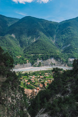 A picturesque wide landscape view of a French medieval village in the valley of Var river in the Alps on a sunny day (Tou&euml;t-sur-Var, Alpes-Maritimes, France)
