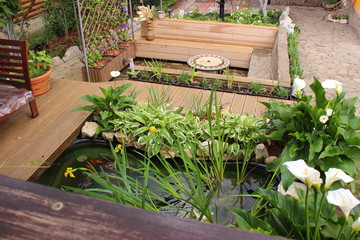 Scene with outdoor pond and patio. Garden lounge