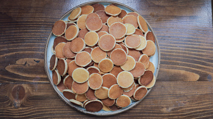 Freshly baked a plate of poffertjes, traditional Dutch Mini Pancakes without any other ingredients with the wooden background