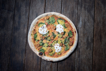 An isolated pizza with a nice old wooden table, ideal for designing text around