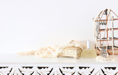 Image of pearls and perfume over white vintage wooden table. For mockup, can be used for photography montage