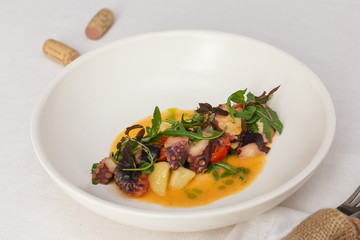 Stewed octopus in vine sauce with arugula
