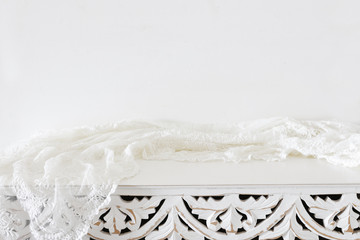background Image of vintage table and lace fabric in front of white wall. ready for product display