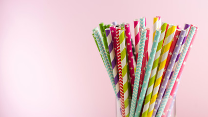Colorful paper tubes for drinks on pink backgrounds. The concept of party, celebration, birthday. Copy space.