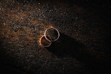 Two golden wedding rings on wooden background