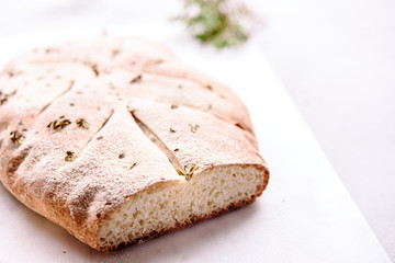 Homemade fresh baked Fougasse (French Bread) with thyme and olive oil on white background. Traditional Provencal dishes. Selective focus