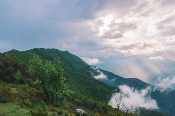 A picturesque wide landscape view of the French Alps mountains covered in clouds in the evening (Col de Rigaudon, Alpes-Maritimes, France)