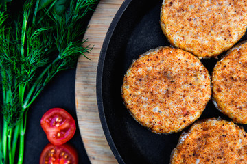 Juicy Meat cutlets on pan. Parsley and tomatoes