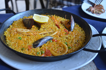 Paella is a Spanish rice dish originally from Valencia. Seafood paella from a local cafe at Barcelona.
