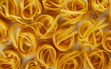 Bird's nest raw uncooked pasta background, top view