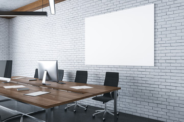 Coworking office interior with blank poster on brick wall.