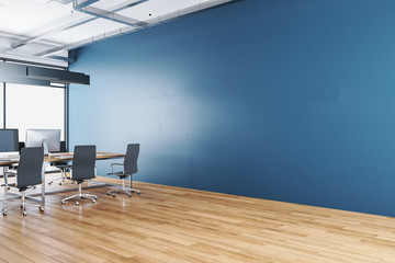 Luxury coworking office interior with city view and empty blue wall.