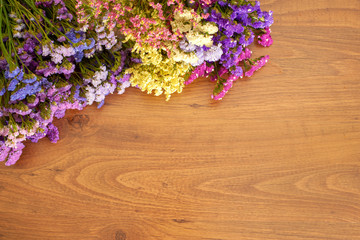 Brown wooden background with statice flower composition