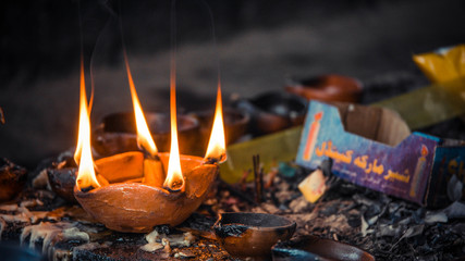 A close up of burning candles in a cup