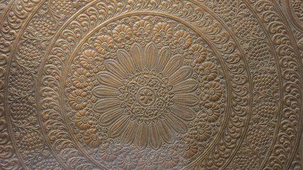 A close up of engraved detail flowers on wood