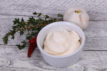 Mayonnaise sauce in the white bowl served thyme and garlic