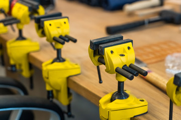 Many Yellow Vises are Set on the Work Bench at the School. New Grips or Jaw Vices Fixed at Woodwork Workshop.