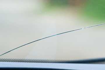 .close-up photo of a cracked windscreen, view from inside of the car